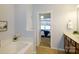 Bathroom with soaking tub, double vanity, and access to bedroom and closet at 8428 Loxton Cir, Charlotte, NC 28214