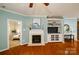 Living room with fireplace, built-in shelving, and view into bedroom at 8428 Loxton Cir, Charlotte, NC 28214