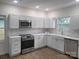 Updated kitchen showcasing stainless steel appliances, including a microwave and electric stove at 401 Woodlawn Ave, Cramerton, NC 28032