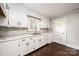 Bright kitchen with white cabinets, modern backsplash, granite countertops, and hardwood floors at 2186 W Nc 10 Hwy, Newton, NC 28658