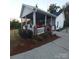 Inviting home exterior with a covered patio featuring a comfortable seating area and lush landscaping at 4000 Wilson Ln, Charlotte, NC 28206