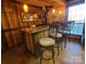 Well-lit bar area featuring wood paneling, a serving area, pendant lighting, and seating for relaxing and entertaining at 4000 Wilson Ln, Charlotte, NC 28206