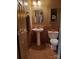 Half bathroom featuring a pedestal sink, toilet, decorative mirror, and tile walls for a sophisticated and modern space at 4000 Wilson Ln, Charlotte, NC 28206