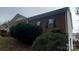 Brick home featuring dark shutters, green bushes, and a sloped lawn at 4000 Wilson Ln, Charlotte, NC 28206