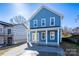 Charming blue two-story home with a welcoming front porch and newly paved driveway at 518 Herms Ave, Mount Holly, NC 28120