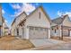 Attached garage with a carriage-style door, exterior lighting and a concrete driveway at 613 Hops Aly, Fort Mill, SC 29715