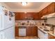 Galley kitchen with wood cabinets, double sink, and standard appliances at 3722 Park Rd # Q, Charlotte, NC 28209