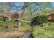 Picturesque backyard with stream, lush landscaping, and mature trees at 1652 12Th Ne St, Hickory, NC 28601