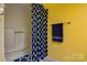 Shower stall with blue pattern curtain and a towel bar against yellow wall at 1652 12Th Ne St, Hickory, NC 28601