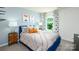 Bright bedroom with blue accent wall, patterned curtains, and a view of the greenery outside at 3880 Maxwell Henry Nw Ln, Conover, NC 28613