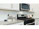 Modern kitchen boasts stainless steel oven, microwave, white cabinets, and granite countertops at 3880 Maxwell Henry Nw Ln, Conover, NC 28613