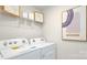 Functional laundry room with modern washer and dryer, storage shelves, and bright lighting at 3880 Maxwell Henry Nw Ln, Conover, NC 28613