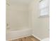 Bathroom with a white shower-tub combo next to a window at 1623 Forest Stream Ct, Charlotte, NC 28213