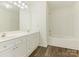 Bathroom featuring a double vanity, large mirror, and a shower-tub combo at 1623 Forest Stream Ct, Charlotte, NC 28213