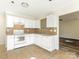 Kitchen featuring a tile floor, white appliances, and a serving opening to the living room at 1623 Forest Stream Ct, Charlotte, NC 28213