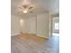 Living room with wood-look flooring, white trim, and multiple doorways leading to other rooms at 4342 Allenby Pl, Monroe, NC 28110