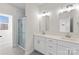 Modern bathroom with double vanity, large mirror, and glass shower at 8603 Mcclure Cir, Charlotte, NC 28216