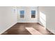 Sunny bedroom featuring hardwood floors and two large windows at 8603 Mcclure Cir, Charlotte, NC 28216