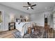 Cozy bedroom with a ceiling fan, soft lighting, a large window, and wood floors at 271 Lockhard Cir, Troutman, NC 28166