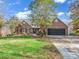 Charming brick home featuring mature landscaping, a black two-car garage, and a welcoming front entrance at 271 Lockhard Cir, Troutman, NC 28166