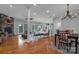 Open concept living room with stone fireplace, hardwood floors, dining area, and plenty of natural light at 271 Lockhard Cir, Troutman, NC 28166