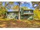 Green two-story home with a screened porch overlooking a yard filled with trees at 11429 Spreading Oak Ln, Charlotte, NC 28226