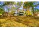 Wide shot of a green home with a screened porch surrounded by trees and a grassy yard at 11429 Spreading Oak Ln, Charlotte, NC 28226