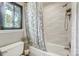 This bathroom includes a decorative showerhead and a view from the window looking out to green foliage at 11429 Spreading Oak Ln, Charlotte, NC 28226