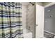 Up close, a bathroom is shown with decorative shower curtain and matching tile work, along with modern fixtures at 11429 Spreading Oak Ln, Charlotte, NC 28226