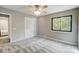 A calming bedroom is shown with a large window, a ceiling fan, and a spacious closet with bi-fold doors at 11429 Spreading Oak Ln, Charlotte, NC 28226