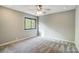 A neutral bedroom with a ceiling fan and a window providing natural light, showcasing a cozy and inviting space at 11429 Spreading Oak Ln, Charlotte, NC 28226