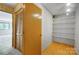Organized closet space with shelves and ample storage, featuring a warm wooden door at 11429 Spreading Oak Ln, Charlotte, NC 28226