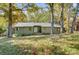 Exterior view of a one-story house surrounded by mature trees and a grassy yard at 11429 Spreading Oak Ln, Charlotte, NC 28226