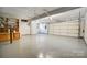 A clean and organized garage space with white walls, painted flooring, and ample storage at 11429 Spreading Oak Ln, Charlotte, NC 28226