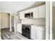 Bright kitchen featuring new white cabinets, quartz countertops, stainless steel refrigerator, and black oven at 11429 Spreading Oak Ln, Charlotte, NC 28226