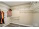 A spacious walk-in closet featuring wire shelving and gray wood-look flooring, providing ample storage at 11429 Spreading Oak Ln, Charlotte, NC 28226