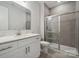Clean bathroom with white vanity, gray tile shower, and a large mirror at 117 Jentri Way, Mooresville, NC 28115