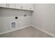 Convenient laundry room with white cabinets and gray tile flooring at 117 Jentri Way, Mooresville, NC 28115