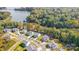 Aerial view of a residential community with manicured lawns, tree-lined streets, and lake access at 4116 Spring Cove Way, Belmont, NC 28012
