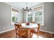 Sunlit dining room with wood table and chairs, hardwood floors, a modern chandelier, and natural lighting at 4116 Spring Cove Way, Belmont, NC 28012