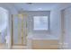 A bathroom with a glass shower and large soaking tub, and a toilet at 6416 Red Maple Dr, Charlotte, NC 28277
