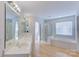 This bathroom has a large mirror, a large tub, a walk-in shower, and wood-look flooring at 6416 Red Maple Dr, Charlotte, NC 28277