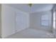 This bedroom has carpet floors, a window with blinds, and a closet with bi-fold doors at 6416 Red Maple Dr, Charlotte, NC 28277