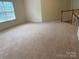 Spacious bonus room with neutral carpet, natural light, and staircase access at 6416 Red Maple Dr, Charlotte, NC 28277