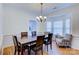 Formal dining room with a wooden table, leather chairs, chandelier, and access to the kitchen at 6416 Red Maple Dr, Charlotte, NC 28277