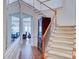 Elegant foyer with staircase, wood floors, decorative mirror, and a view into the dining room with chandelier at 6416 Red Maple Dr, Charlotte, NC 28277