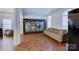 Bright living room featuring hardwood floors, decorative screen, comfortable seating, and arched windows at 6416 Red Maple Dr, Charlotte, NC 28277
