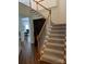 Elegant staircase with carpeted steps, wooden handrail, and large foyer at 6416 Red Maple Dr, Charlotte, NC 28277