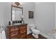 Elegant powder room featuring a wood vanity, granite countertop, and decorative mirror at 5303 Shasta Hill Ct, Charlotte, NC 28211