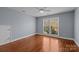 Sun-filled bedroom features hardwood floors, neutral decor, and a large window for natural light at 5303 Shasta Hill Ct, Charlotte, NC 28211